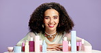 Woman face, makeup or product range in studio for  dermatology, skincare or morning routine. Beauty, confident or female person with cosmetic selection, facial treatment or smile on purple background