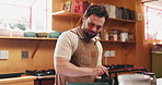 Cooking, man and tablet with mortar in kitchen to grind herbs, online recipe or hospitality industry. Private chef, tech or crush ingredients in home for meal prep, personalized menu and web tutorial