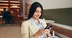 Happy, woman and texting in restaurant with phone, notification and email for good news. Smile, female entrepreneur and tablet in cafe with mobile, reading message and negotiation for business.
