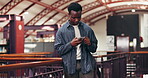 African man, scrolling and reading in library with phone, notification and email for university assignment. Student, person or message in school study with mobile, education or digital for online app