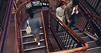 People, walking and library with staircase above of modern or historic museum for safety in archive. Top view, group or students on stairs or floor for learning, education or knowledge in bookstore