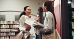 Girl, university student and friends at library, talk or smile with literature for project at academy. Women, happy people and chat with research, education and learning for scholarship at college