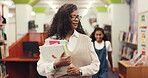 Woman, teacher and walking with books in library for search, bookshelf assessment and education. Mature person, child and run for hug, bonding together and learning resources of knowledge development