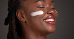 Skincare, cream and happy with black woman in studio for facial moisturizer, cosmetics and self care. Dermatology, collagen lotion and beauty treatment with person on dark background for glow