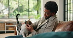 Break, love or stroke with cat and man on sofa in living room of home together for bonding. Comfort, cuddle or relax with kitten and pet owner in apartment for adoption, animal care or welfare