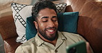 Smile, mobile and man relax on sofa for social media, reading notification and laugh above. Phone, home and happy person in living room for meme, play game and scroll for online chat with top view