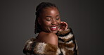 Smile, black woman and touch with luxury skincare in studio for cosmetics, dermatology and glamour. Female person, beauty and fur coat for aesthetic, healthy skin and natural shine on dark background