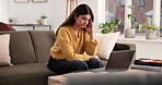 Headache, laptop and stress with woman on sofa in living room of home for budget or finance. Anxiety, computer and migraine with Indian person in apartment for investment, savings or wealth mistake
