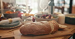 Bread, table setting and thanksgiving with food in dining room of home for social gathering. Dinner, loaf and meal with freshly baked roll in apartment for celebration, event or holiday tradition