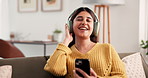 Singing, cellphone and woman with headphones, audio streaming and stress relief. Happiness, home and person on sofa, smartphone or dancing in lounge, sounds and smile with digital app, music or relax