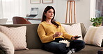 Woman eating, popcorn and watching tv in home with remote for entertainment, film or relax on weekend. Click, streaming service and female person with snack in apartment for movie, show and series.