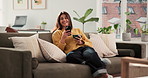 Happy woman, phone and coffee on sofa with face, funny chat and relax with online dating in home. Person, smartphone and tea cup with contact, mobile app and laugh with social media at Colombia