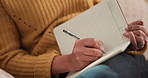Woman, hands and writing with book for schedule, diary reminder or checklist on sofa in home. Female person, planner or writer with notebook or pen for daily schedule, tasks or planning activities