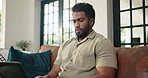 Laptop, confused and man on sofa in home with freelance career for creative project in living room. Stress, technology and male editor with computer for research on article for publishing in house.