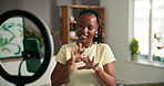 Broadcast, phone and ring light with black woman influencer in home living room for engagement. App, live streaming and recording with happy African content creator in apartment for interaction