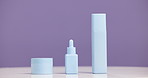 Bottle, product and advertising for skincare in studio, moisturizer and serum mockup on purple background. Beauty, container and marketing for cosmetic care, dermatology selection and presentation