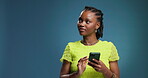 Thinking, space and black woman in studio with phone, doom scroll and chat on social media. Happy, digital and girl on blue background with mobile, communication update or game subscription on app.