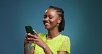 Laugh, scroll and black woman in studio with phone, communication and funny post on social media. Happy, digital and girl on blue background with mobile, meme reaction or game subscription on app.
