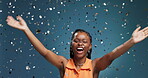 Black woman, winning and celebration with confetti in studio for bonus prize on blue background. Victory, female person and excited model with achievement, dance and success for party or jackpot