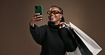 Black woman, selfie and shopping bag in studio, smile and sunglasses with post for fashion sale on background. Girl, happy influencer and photography for customer experience, discount or social media