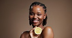 Skincare, face and happy woman with lemon in studio for vitamin c, health and nutrition. Natural beauty, fruit and African model with organic cosmetics, detox and portrait on brown background space