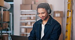 Warehouse, boxes and man with headphones, laptop and planning for stock distribution or supply chain. Streaming, entrepreneur and person with tech for logistics, dance and listen to music in startup
