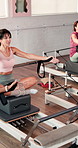 Pilates class, instructor or reformer with demonstration for stretching, instructions or core stability. Yoga studio, above and people on equipment for resistance exercise and guidance on proper form