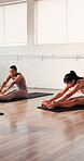 Pilates, stretching and women in class, training and workout routine for wellness, group and fitness. Active, people and exercise with instructor, healthy and warm up on mat with sportswear in gym