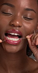 Black woman, dental floss and face in studio, oral wellness and product for plaque with fresh breath. Person, happy and thread for dirt removal, cleaning teeth and gum disease prevention in Nigeria
