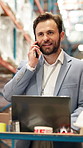 Laptop, phone call and smile of man in warehouse for delivery or logistics management. Communication, computer and planning with happy employee in factory or plant for distribution, stock and storage