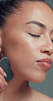 Beauty, gua sha and massage with woman in studio for cosmetics, dermatology or wellness routine. Aesthetic, facial treatment and skincare with model on gray background for circulation or drainage