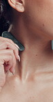 Hands, woman and gua sha for skincare in studio with neck massage, circulation and self care. Person, cosmetic tools and beauty with skin lifting, lymphatic drainage and collagen on gray background