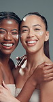Face, women and friends with skincare cream for beauty, dermatology and laugh. Portrait, lotion cosmetics and funny models in studio together with moisturizer, glow and embrace on gray background