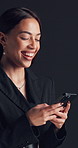Businesswoman, typing and laughing in studio with phone for social media, funny conversation and chat. Happy, person and scroll with tech for online meme, text message and humor on black background.