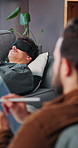 Psychologist, tablet and man on sofa with blindfold for mental health, sensory awareness and help. Therapist, patient and sleep mask on couch with tech for writing note, counseling and evaluation.