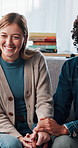 Happy, couple or holding hands in counseling on sofa for communication tips, reconciliation or advice. Appointment, people and consultation in office for pre marriage therapy and relationship growth