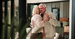 Love, elderly couple and dance in home for anniversary celebration, holding hands and spin. Music, senior man and woman moving in living room for romance, connection and happiness in retirement