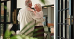 Love, senior couple and dance in home for anniversary celebration, holding hands or spin. Music, elderly man and woman moving in living room for romance, talk or happiness with partner in retirement