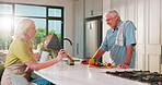 Old man, woman and smell flowers in kitchen with cooking, tablet and flare with present on anniversary. Happy couple, tech and floral bouquet for gift, milestone or celebration with love in home