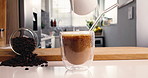 Cream, coffee and hands of person in kitchen of home for morning beverage, brewing or cappuccino liquid. Espresso shot, drink and cup of latte with man in apartment for milk, roast and caffeine
