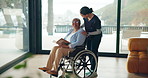 Senior woman, reading book and wheelchair in home with nurse, happy or literature in retirement. Elderly person with disability, mobility aid or rehabilitation for injury, caregiver or story in house