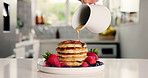 Maple syrup, breakfast and pancakes with hand in kitchen for strawberry, nutrition and health. Fruit, food and dessert or brunch with person and honey on hotcakes in home for snack, cooking and fiber