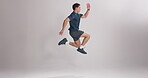 Exercise, cardio and man in studio, jump and training for fitness, mockup space or white background. Healthy, workout and person with energy for routine, wellness and active for practice for sport
