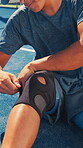 Sports, knee brace and person with injury outdoor at tennis court with pain, exercise or workout. Accident, hurt athlete and ache or wrap for leg muscle, training mistake and strain on turf ground