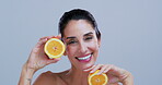 Studio, face and woman with orange, skincare and natural cosmetics for healthy skin and dermatology. Blue background, laugh and mature person with fruit for facial treatment or anti aging benefits
