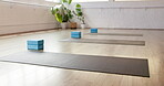Fitness, yoga and mat in gym on floor, preparation and equipment for body wellness class. Start, empty room and setup in studio with support blocks, workout group or beginning of pilates training.