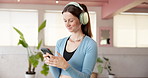 Cellphone, headphones and woman in studio, fitness and listening to music, radio and wellness. Healthy, smartphone and happy person with exercise, podcast or audio with sound, digital app or internet