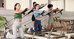 Reformer, pilates and fitness with women in class for exercise, learning and workout instructor. Balance, commitment and teaching with people in yoga studio for machine, holistic and wellness