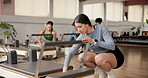 Pilates, friends and reformer machine with women in studio for start, workout and stability. Equipment check, wellness club and inspection with people in fitness class for setup, exercise and health