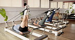Pilates class, reformer and people exercise legs in studio for health, wellness and core strength. Group, women and machine to workout muscle, resistance training and stretching in fitness club